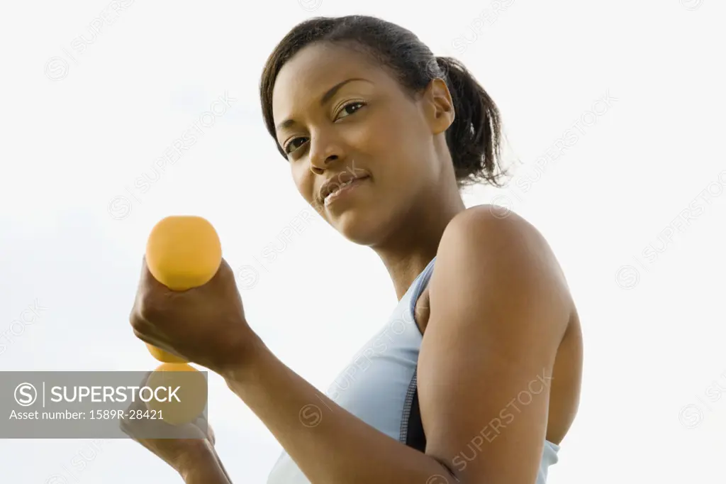 African woman lifting dumbbells
