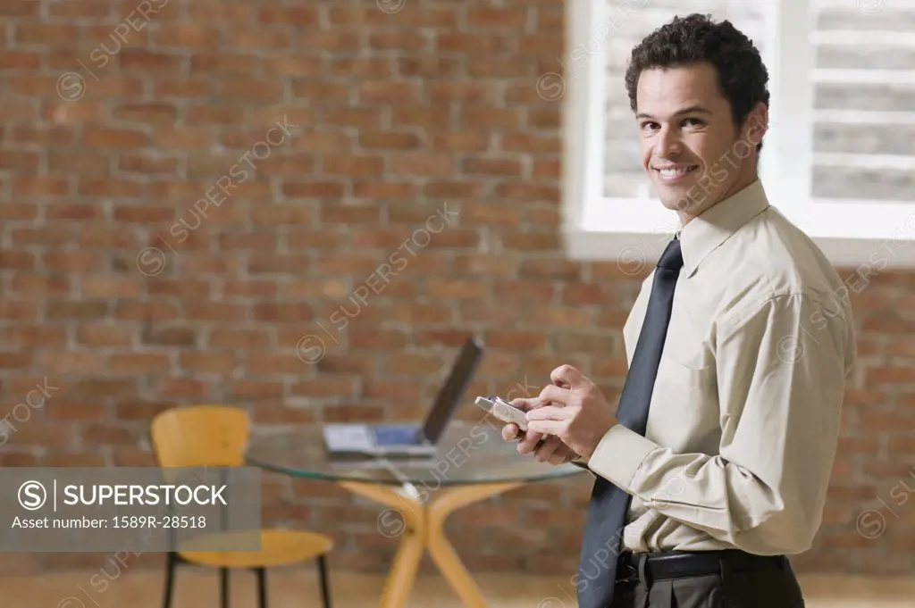 Businessman using PDA indoors
