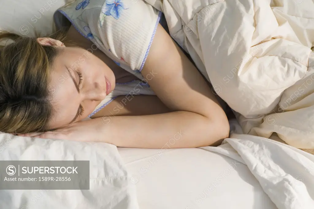 Young woman sleeping in bed