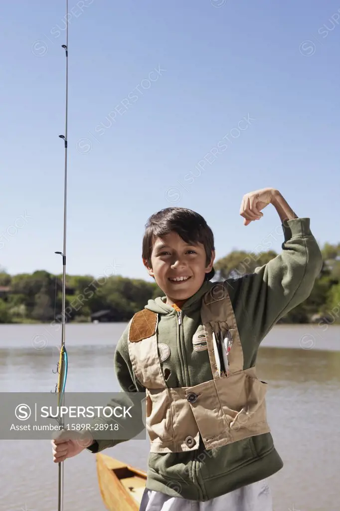 Hispanic boy holding fishing pole outdoors