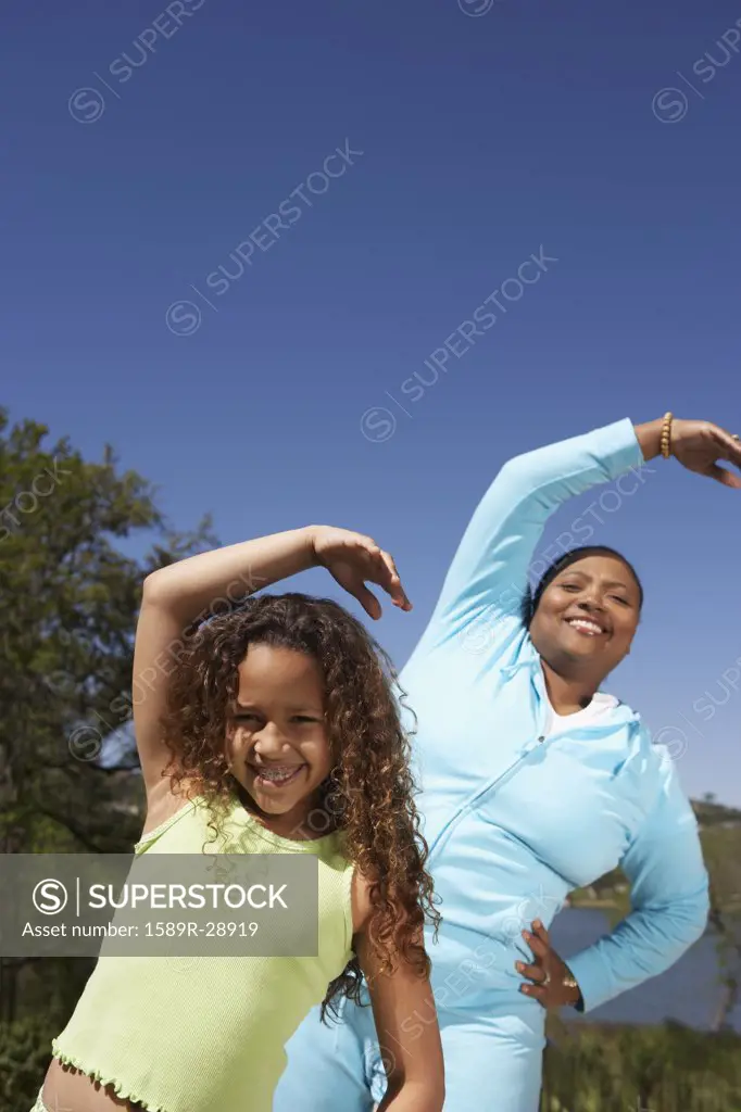 African mother and daughter stretching outdoors