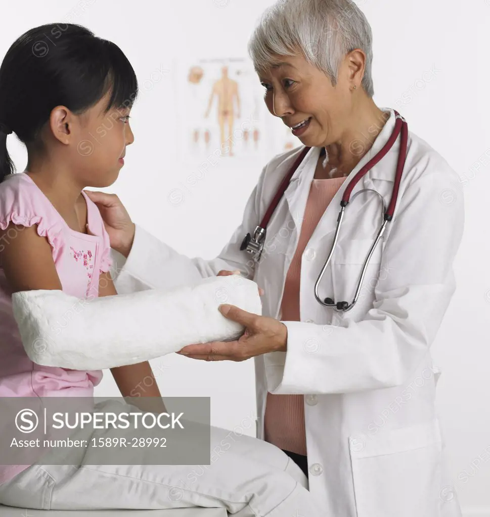 Senior Asian female doctor with young patient
