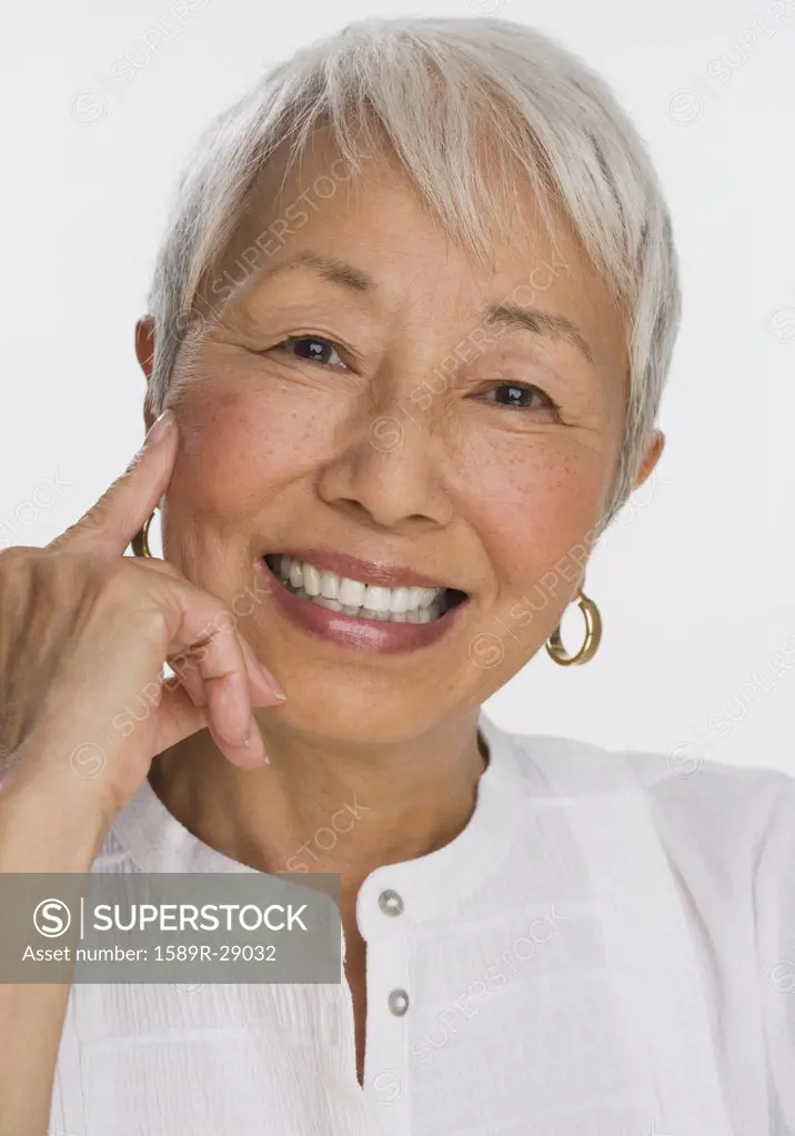 Studio shot of senior Asian woman smiling