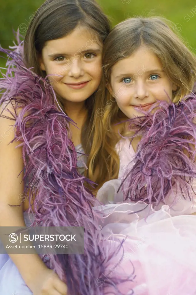 Two young girls wearing feather boa and smiling