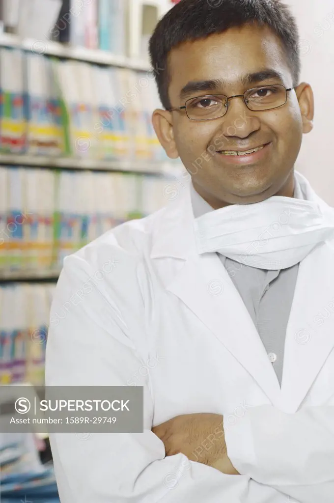 Indian male dentist smiling in office