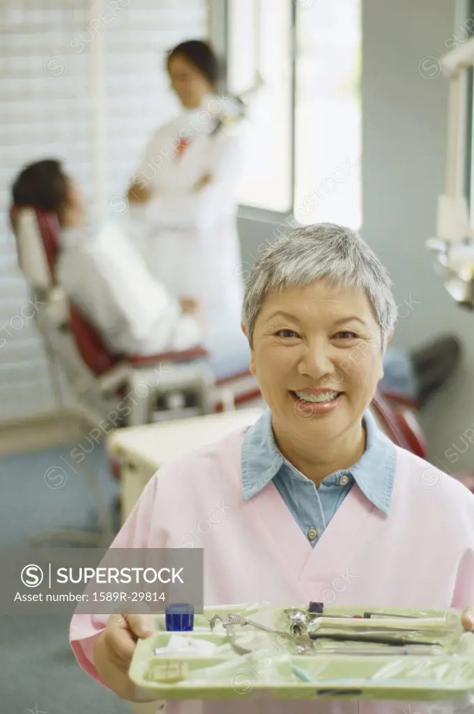 Senior Asian female dental assistant smiling