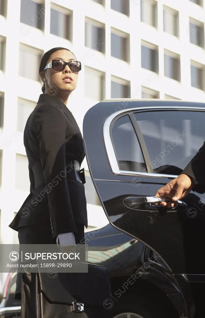 Asian businesswoman getting into town car