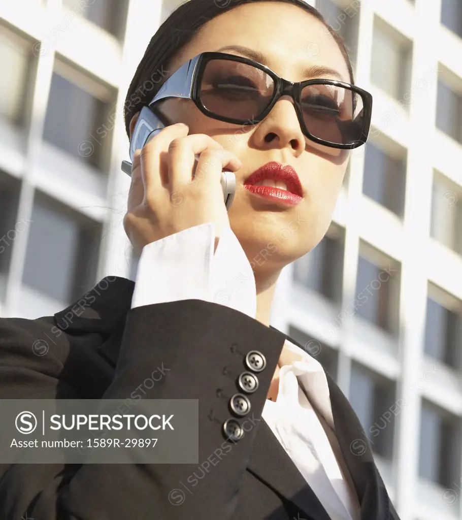 Low angle view of Asian businesswoman using cell phone