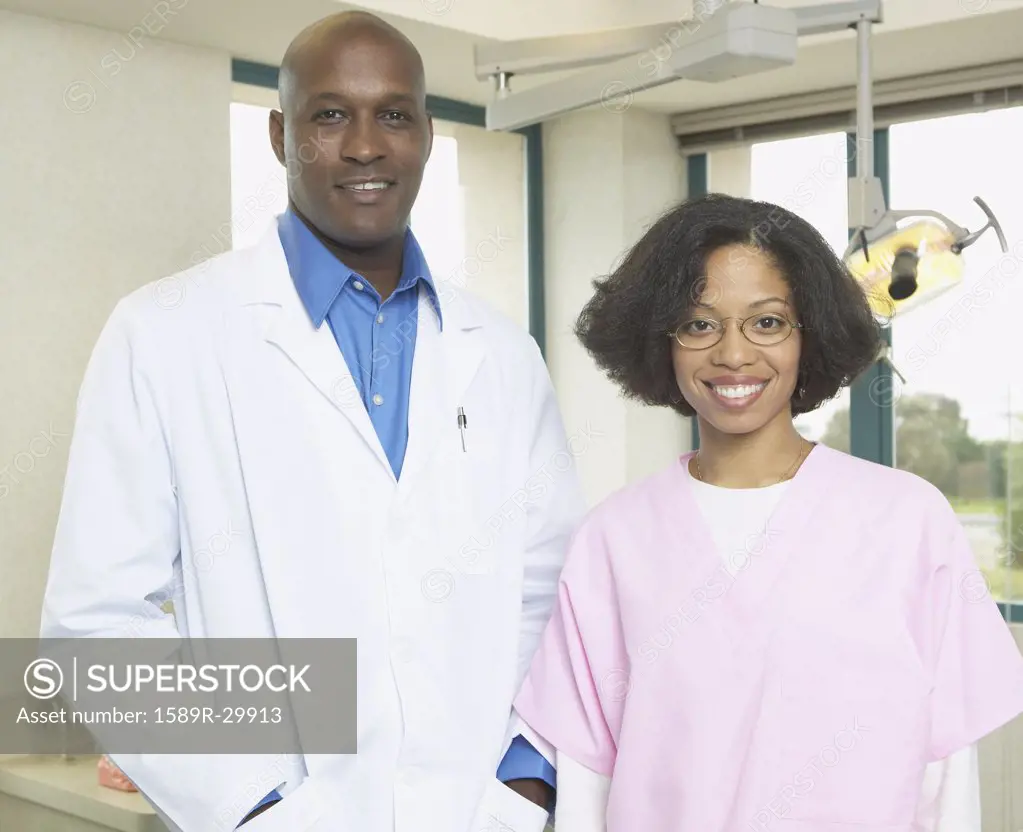 African male dentist with African female dental assistant smiling