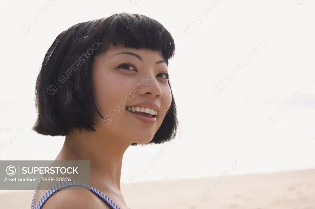 Young Asian woman smiling at beach