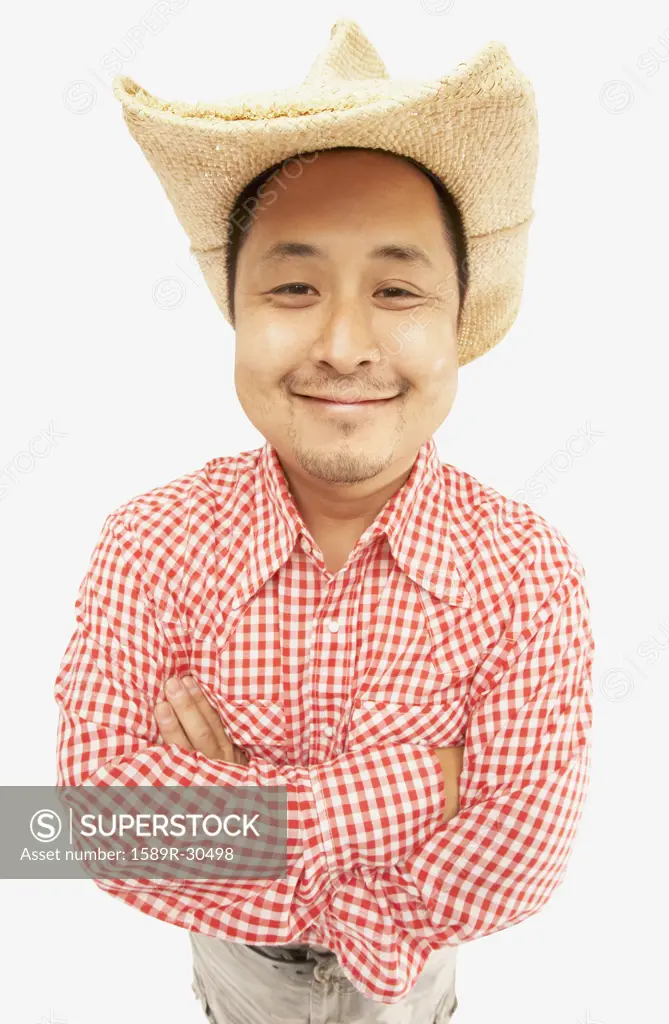 Studio shot of Asian man smiling and wearing cowboy hat