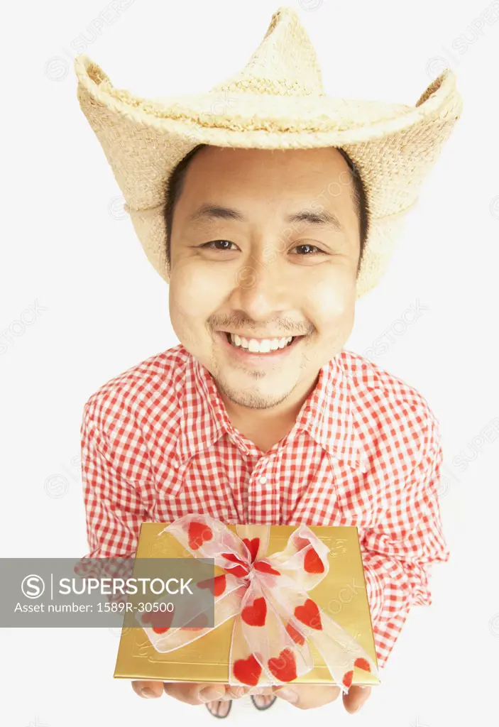 Studio shot of Asian man smiling and holding gift