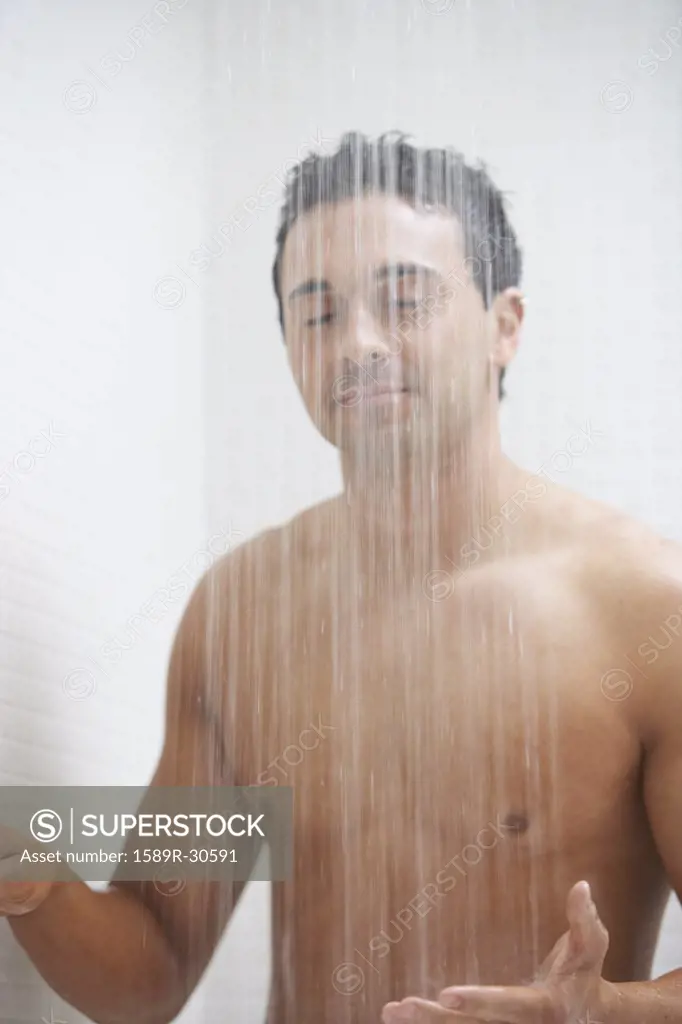 Man with eyes closed in shower