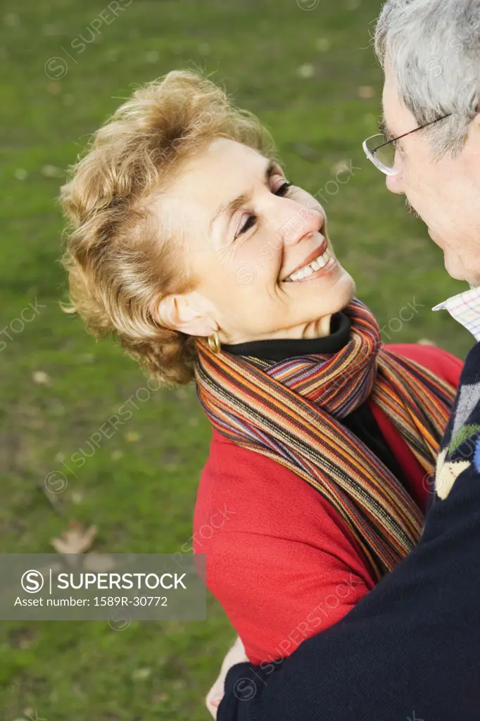Senior couple smiling at each other outdoors