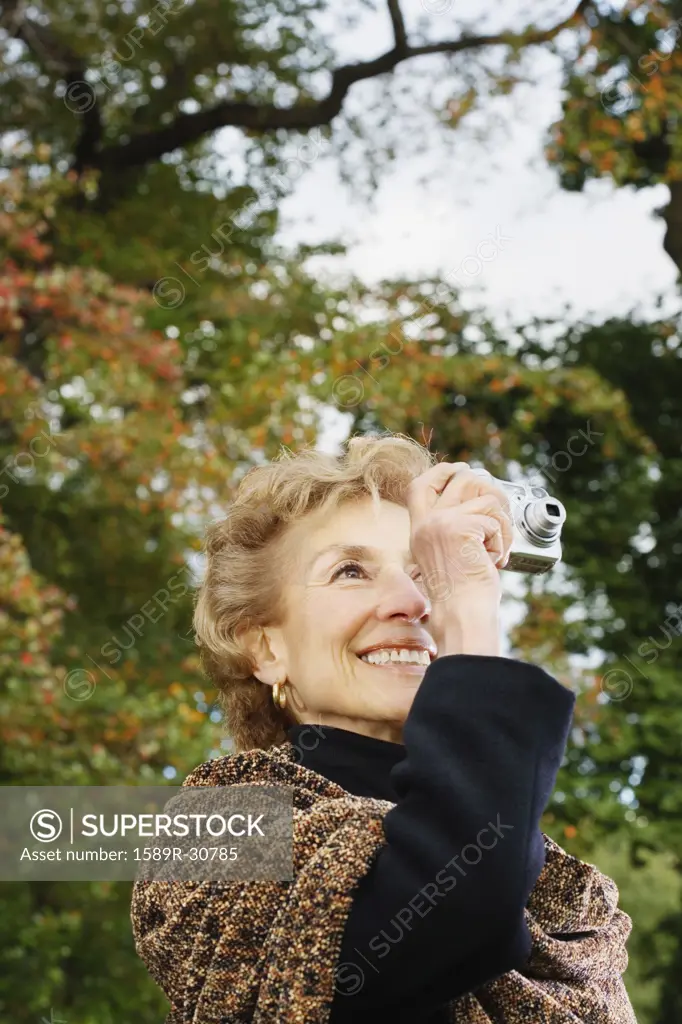 Senior woman taking photograph outdoors