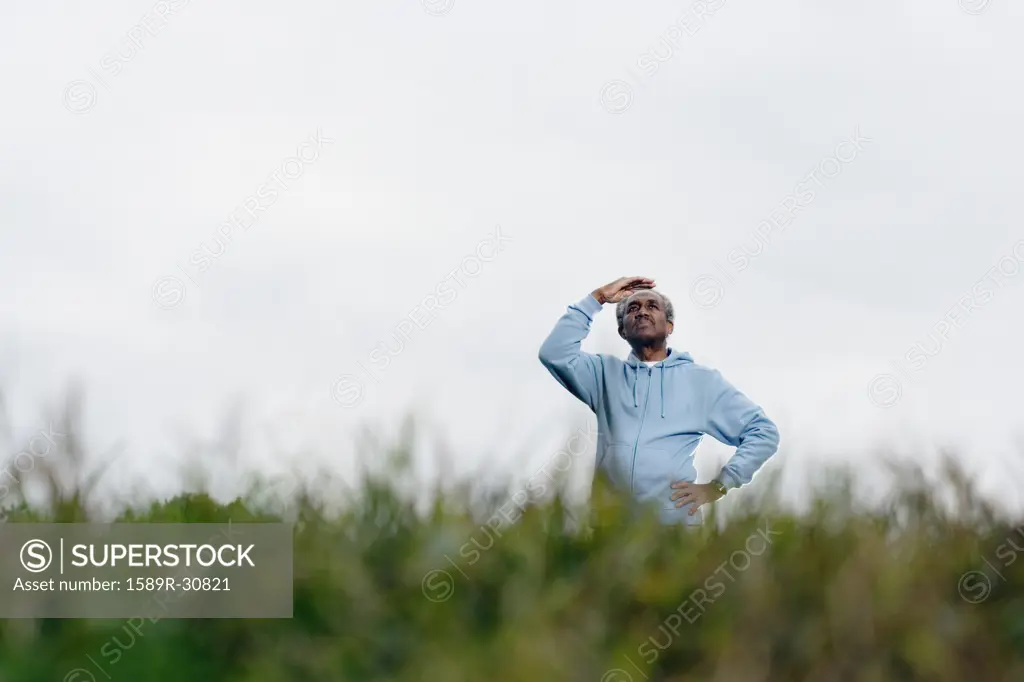 African man shading eyes with hand outdoors