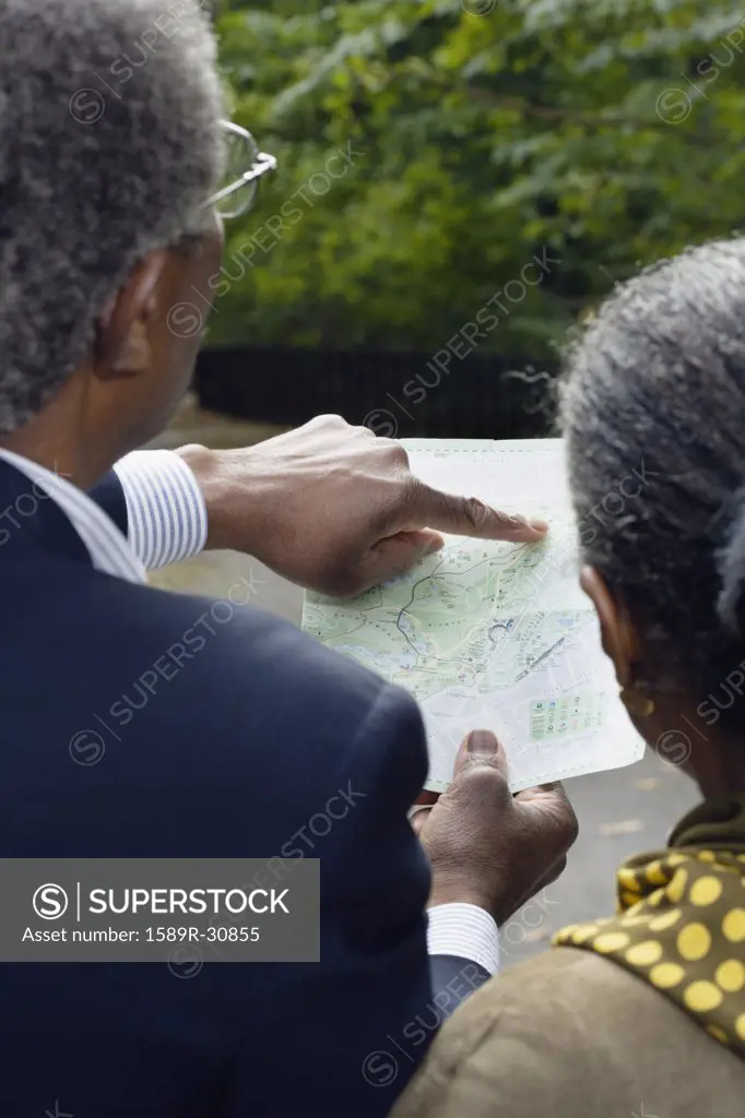 Senior African couple looking at map outdoors