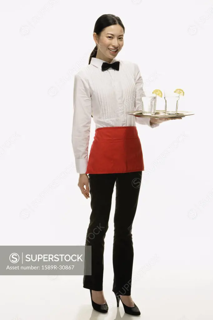 Studio shot of Asian waitress holding tray of drinks