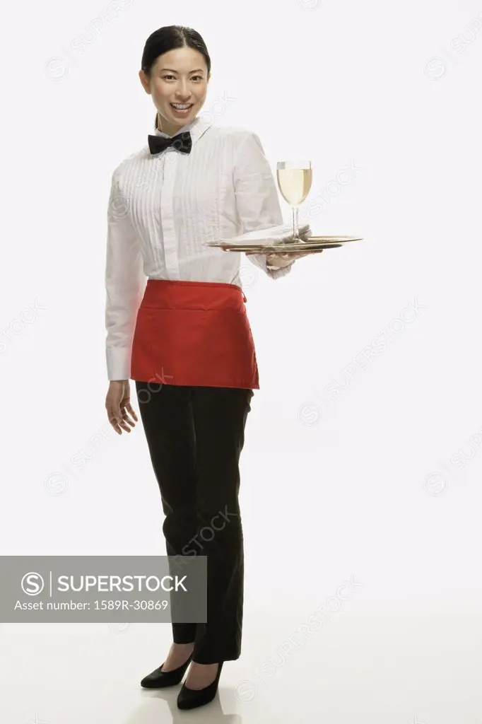 Studio shot of Asian waitress holding tray with wine glass