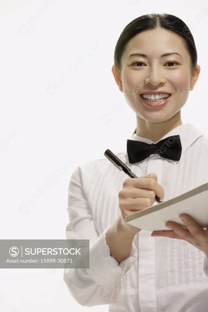 Studio shot of Asian waitress writing food order
