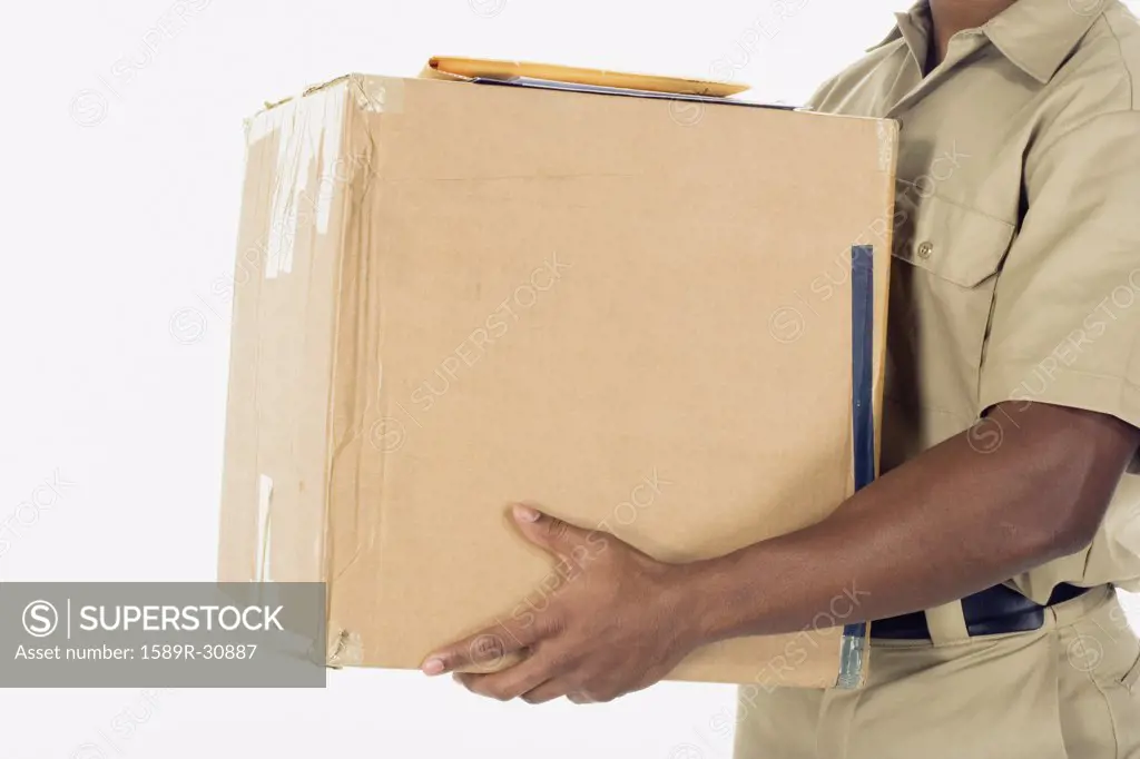 Studio shot of African delivery man with package