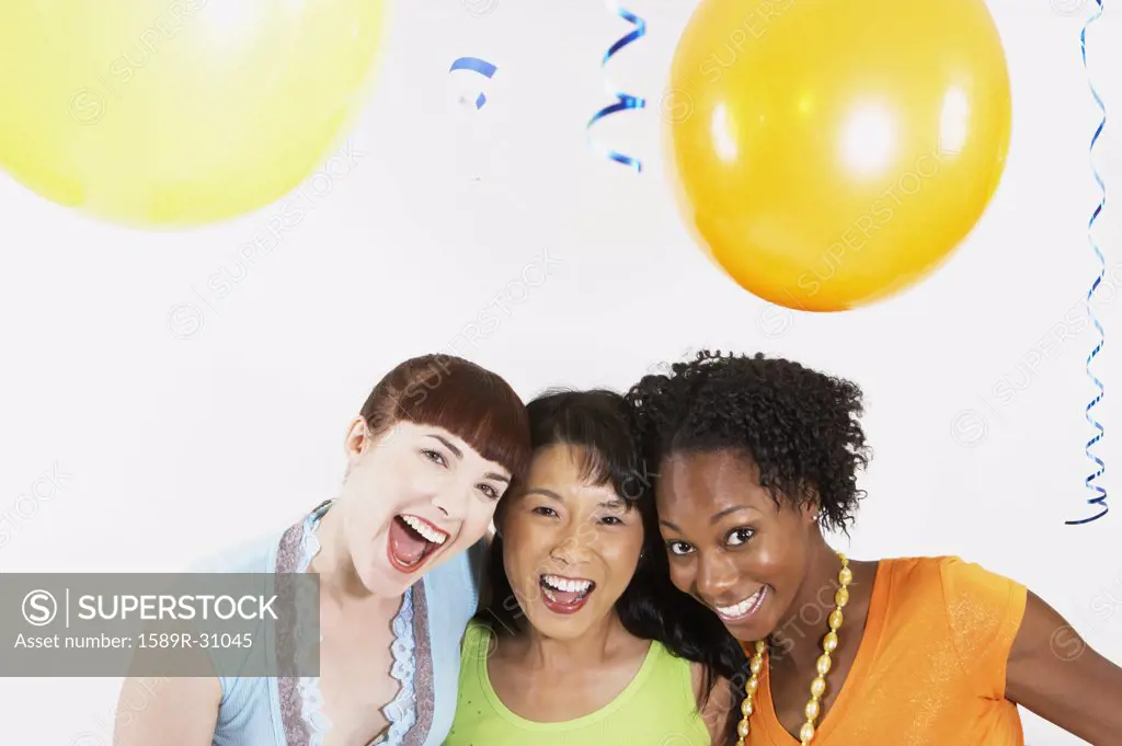 Studio shot of three women smiling with balloons