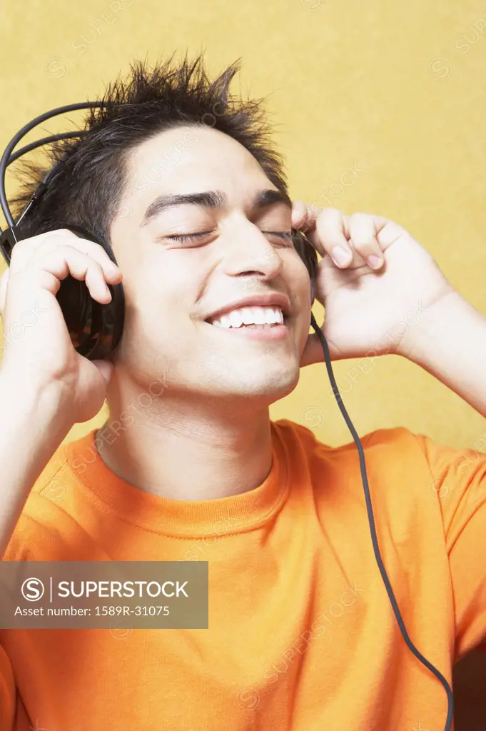 Close up of young man listening to headphones indoors