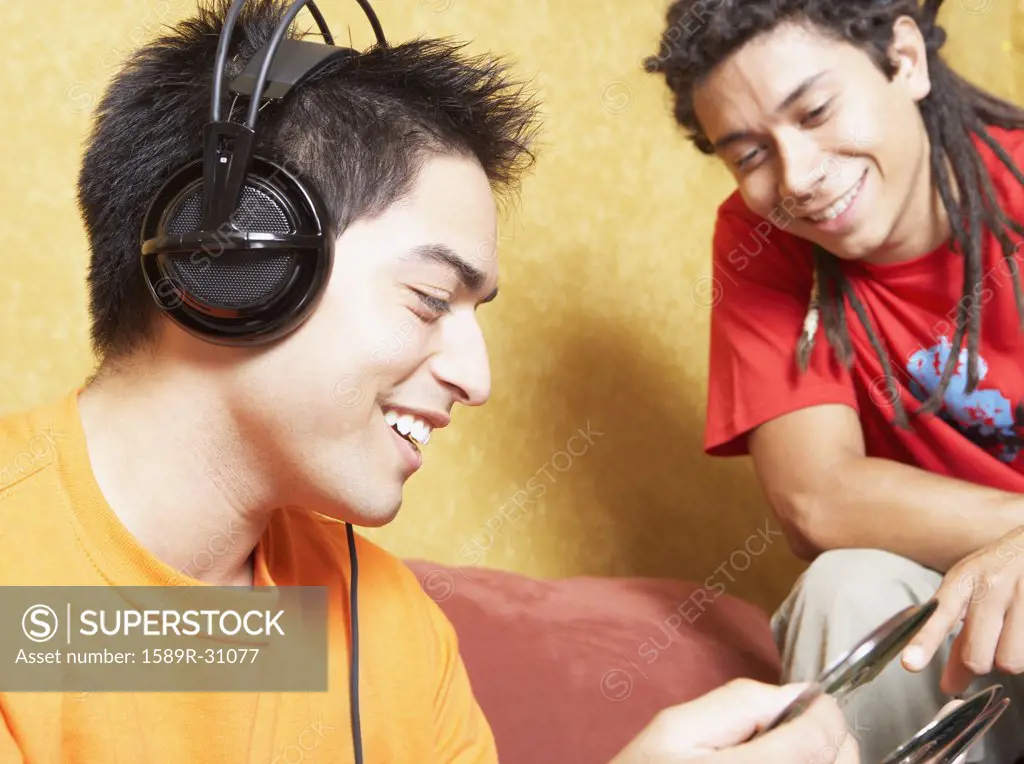 Two young men looking at cds indoors