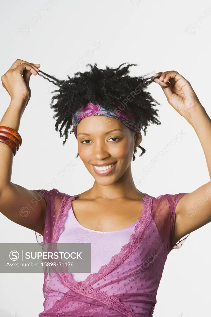 Studio shot of African woman pulling hair