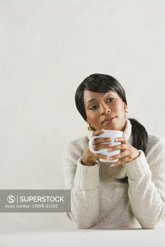 Studio shot of African woman with coffee