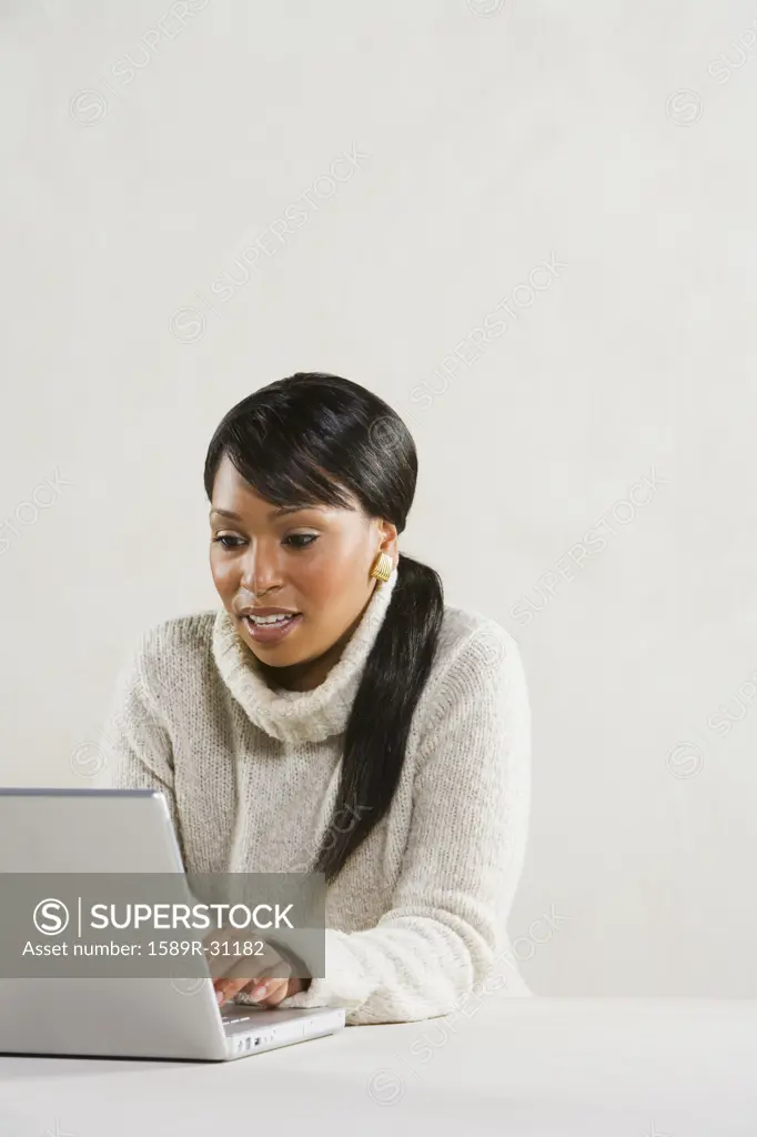 Studio shot of African woman using laptop