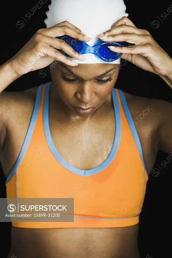 African woman wearing swimming cap and goggles