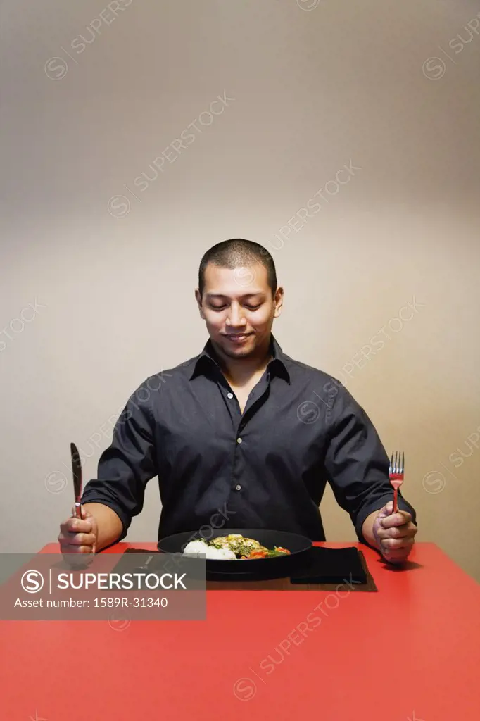 Man sitting at table with full plate of food