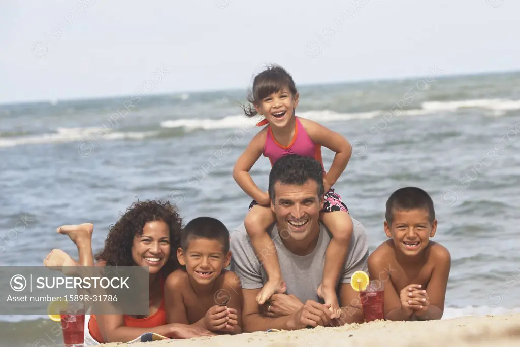 Hispanic family laying on beach