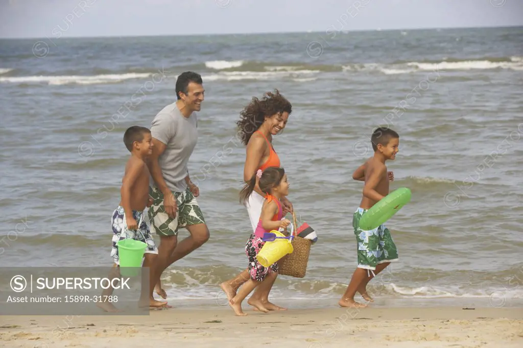 Hispanic family running on beach