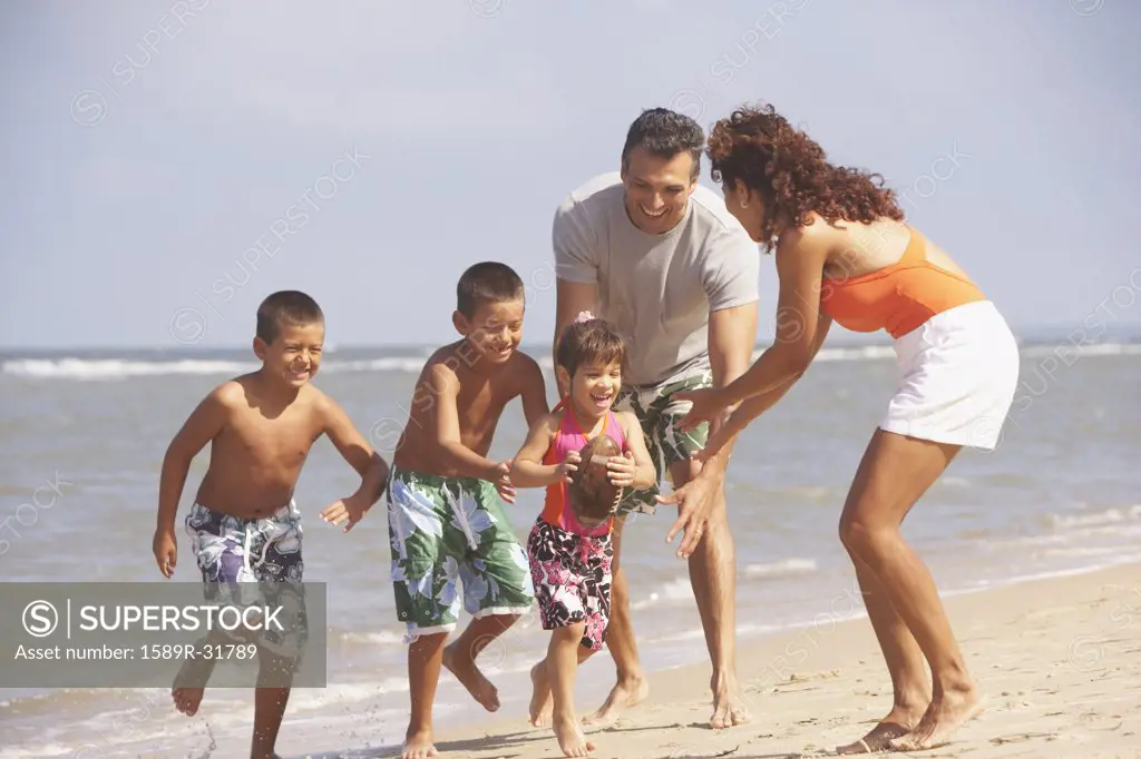 Hispanic family playing at beach