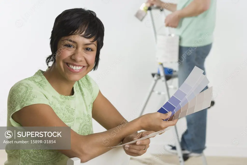 Portrait of Hispanic woman holding paint swatches