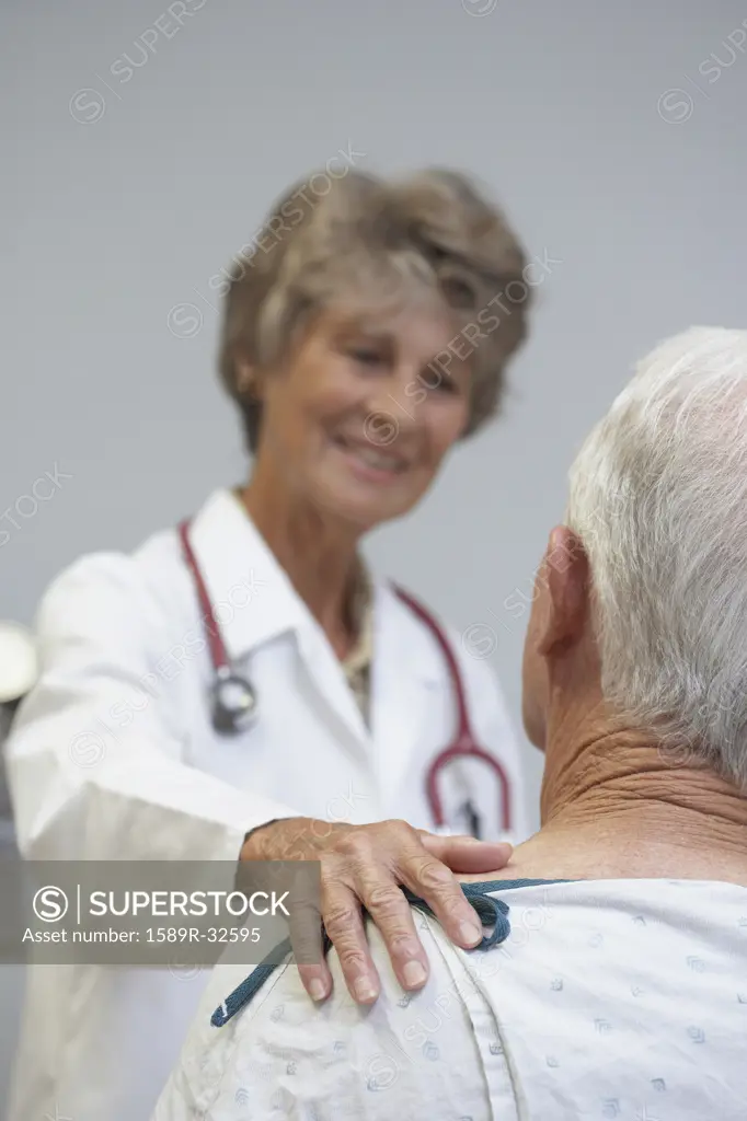 Senior female doctor reassuring senior male patient