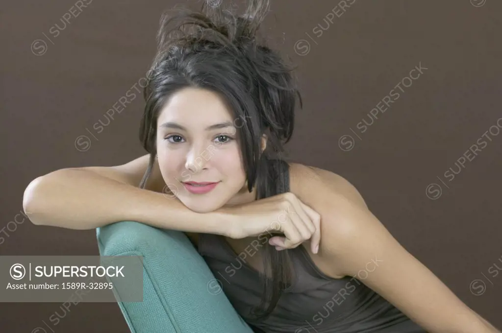 Hispanic girl resting chin on arm
