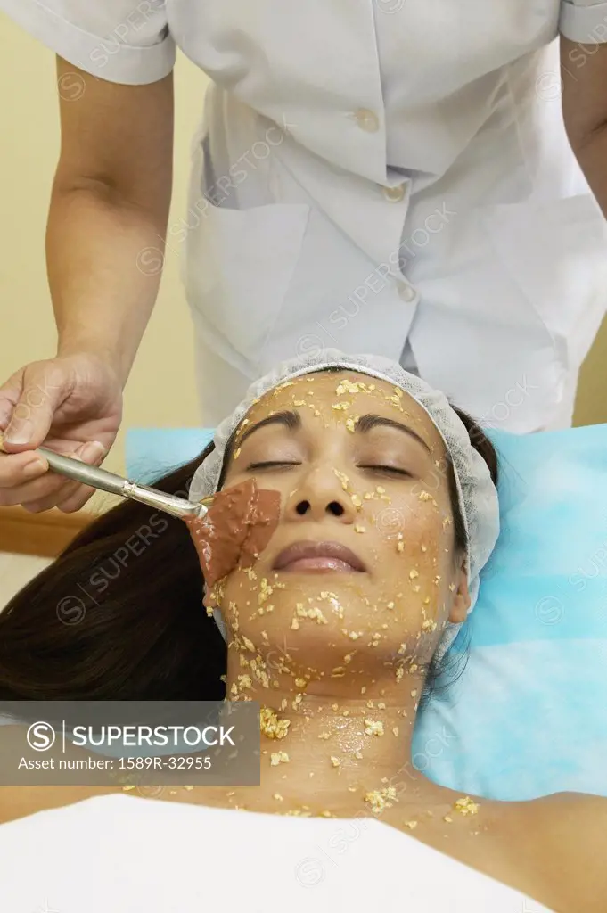 Asian woman receiving facial spa treatment