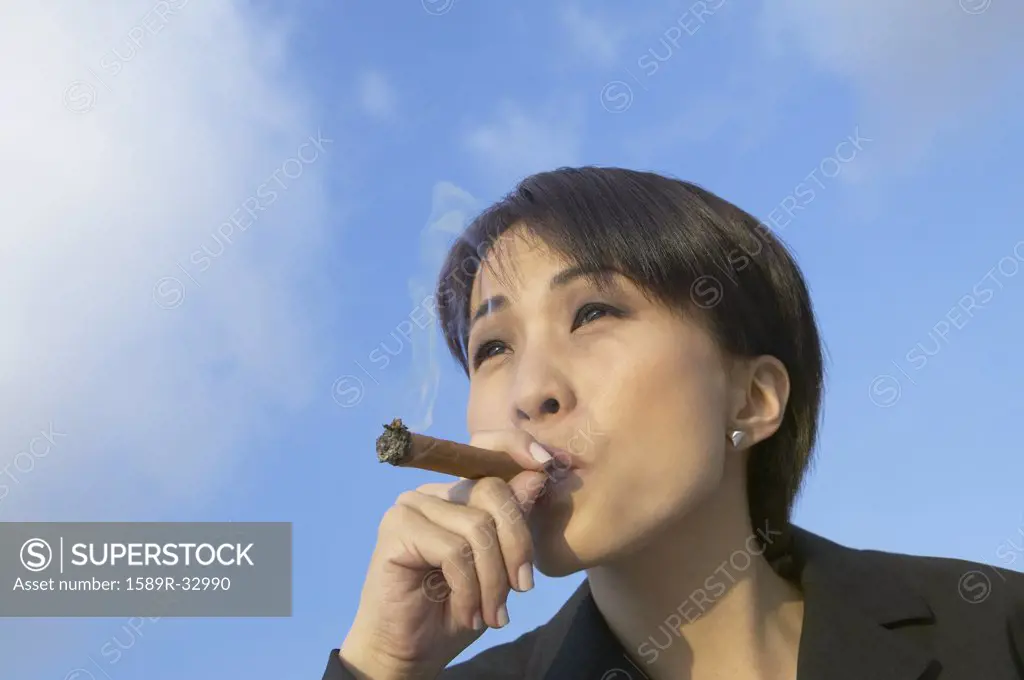 Asian businesswoman smoking cigar