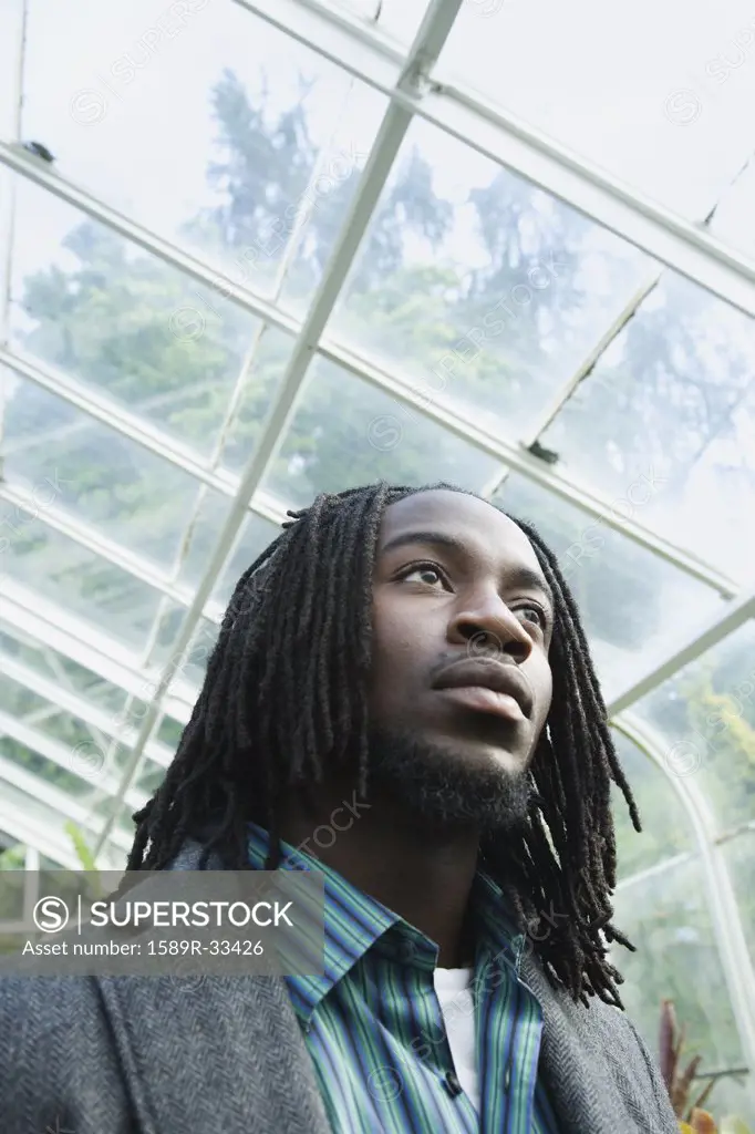 Low angle view of African man in greenhouse