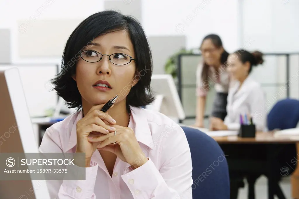 Portrait of Asian businesswoman holding pen