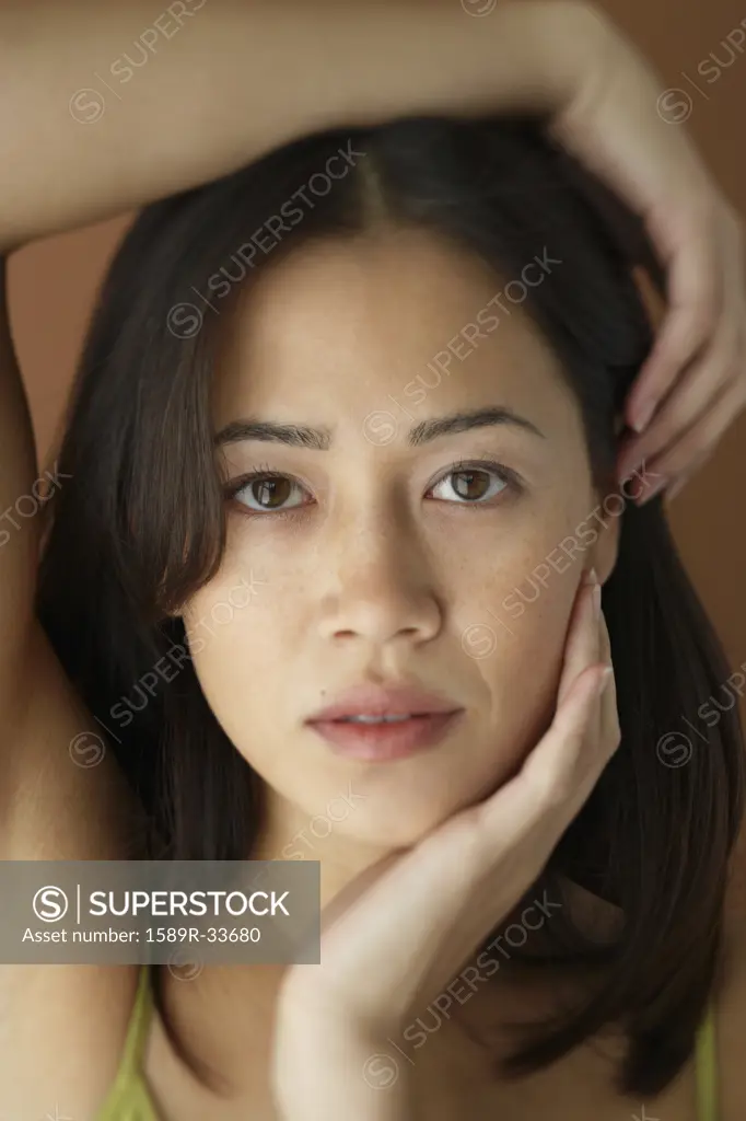 Asian woman with hand on face