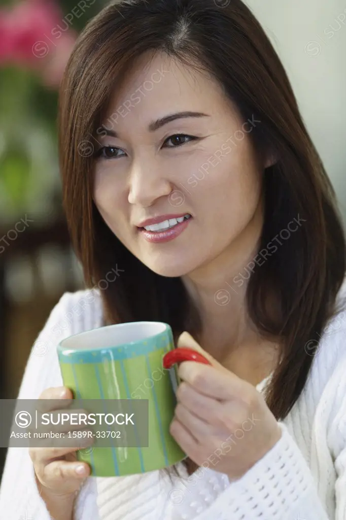 Asian woman holding coffee mug