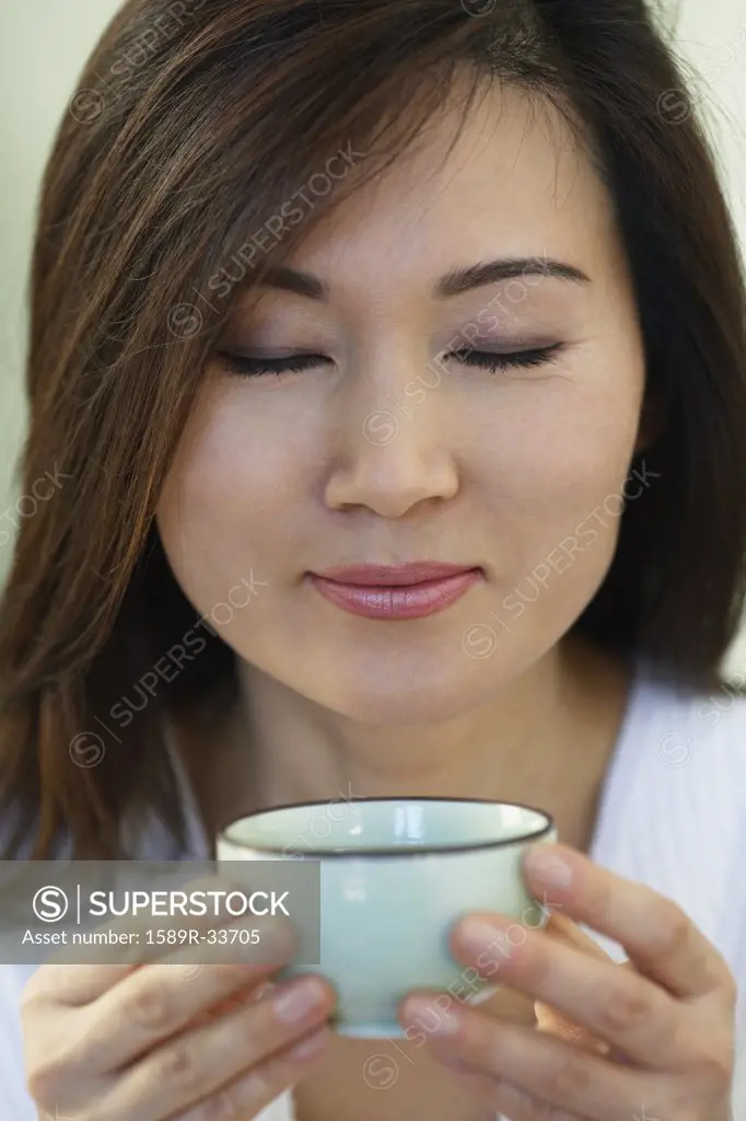 Asian woman holding tea cup