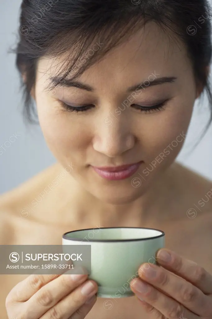 Asian woman holding tea cup
