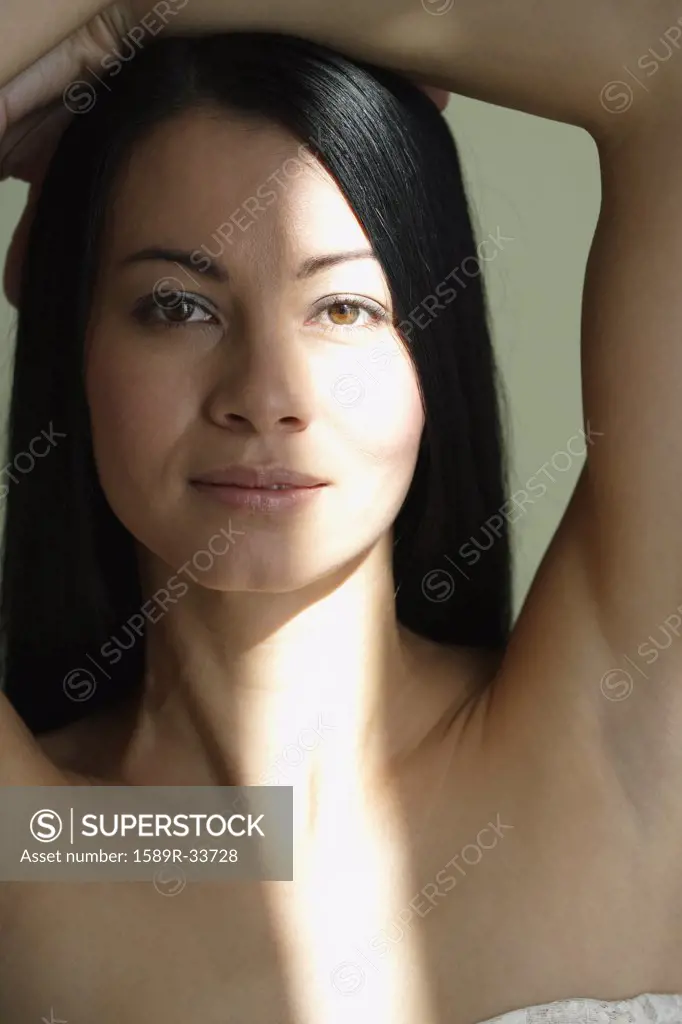 Asian woman with hands on head