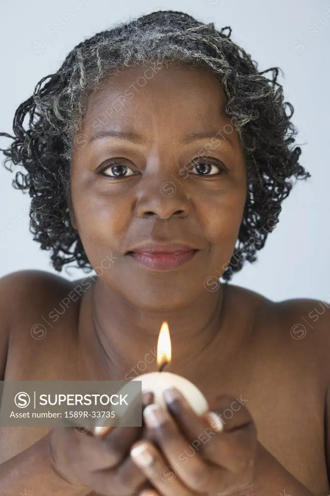 Senior African woman holding candle