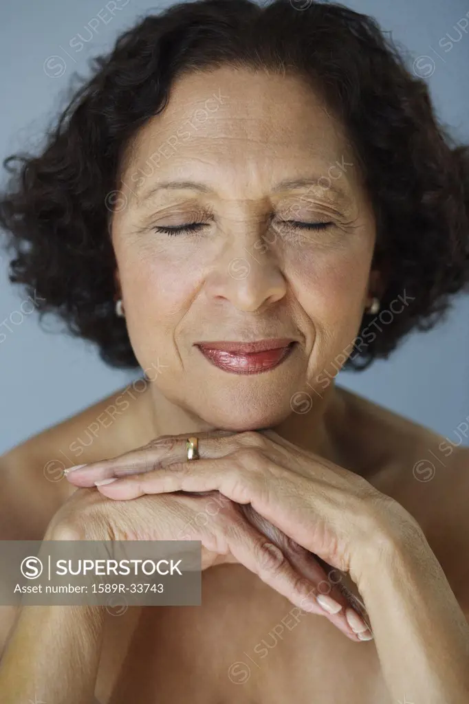 Senior African woman resting chin on hands